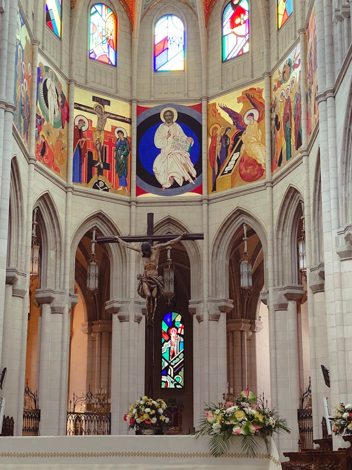 A stunning view of a cathedral's altar with religious art and stained glass.