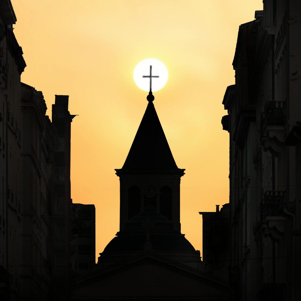 A striking silhouette of a church against a vibrant sunset in Lyon, France.